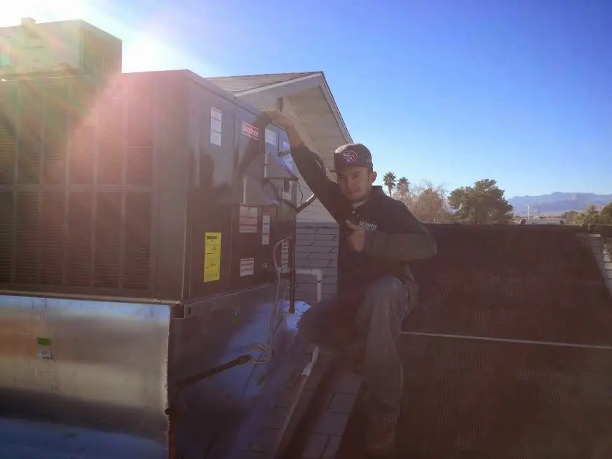 HVAC technician performing Heat Pump Repair on a rooftop unit in Baxter Village